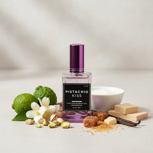 Perfume bottle labeled 'Pistachio Kiss' with pistachios, flowers, and a bowl on a light background