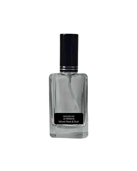 Clear glass perfume bottle with black cap on a white background