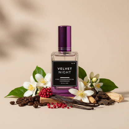 Perfume bottle labeled 'Velvet Night' surrounded by flowers and leaves on a beige background